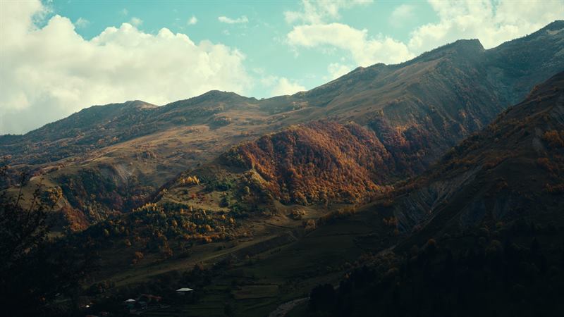 Autumn light crossing a wide valley of bare mountains