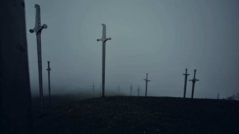 Tall steel crosses on a hilltop in heavy fog