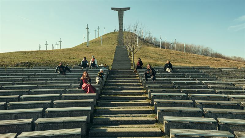 People sitting on the wide steps of a hillside monument