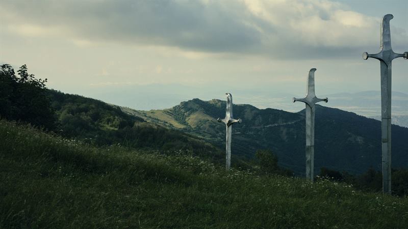 Steel crosses on a green ridge above a valley