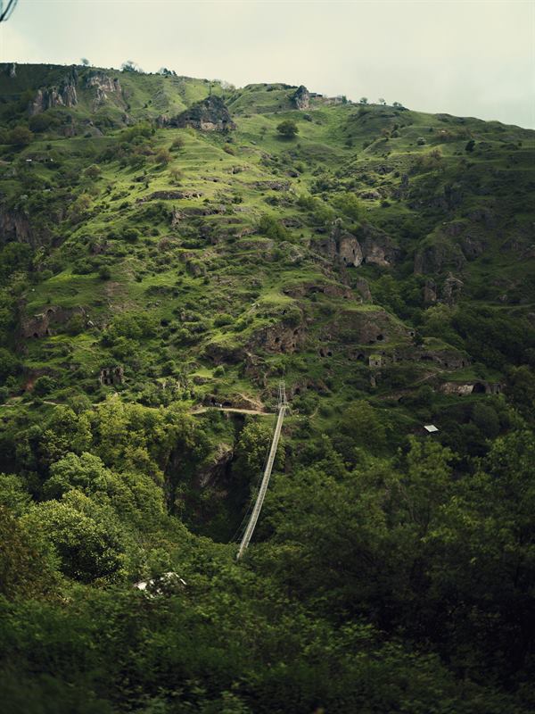 A steep green hillside cut by a rocky outcrop